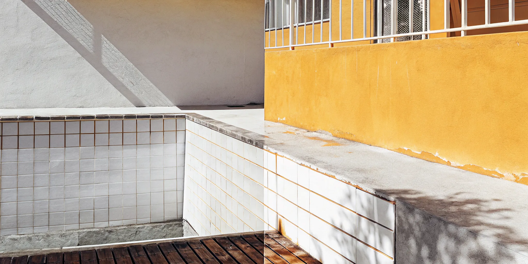A pool with cracked tiles and worn surfaces before a major renovation.