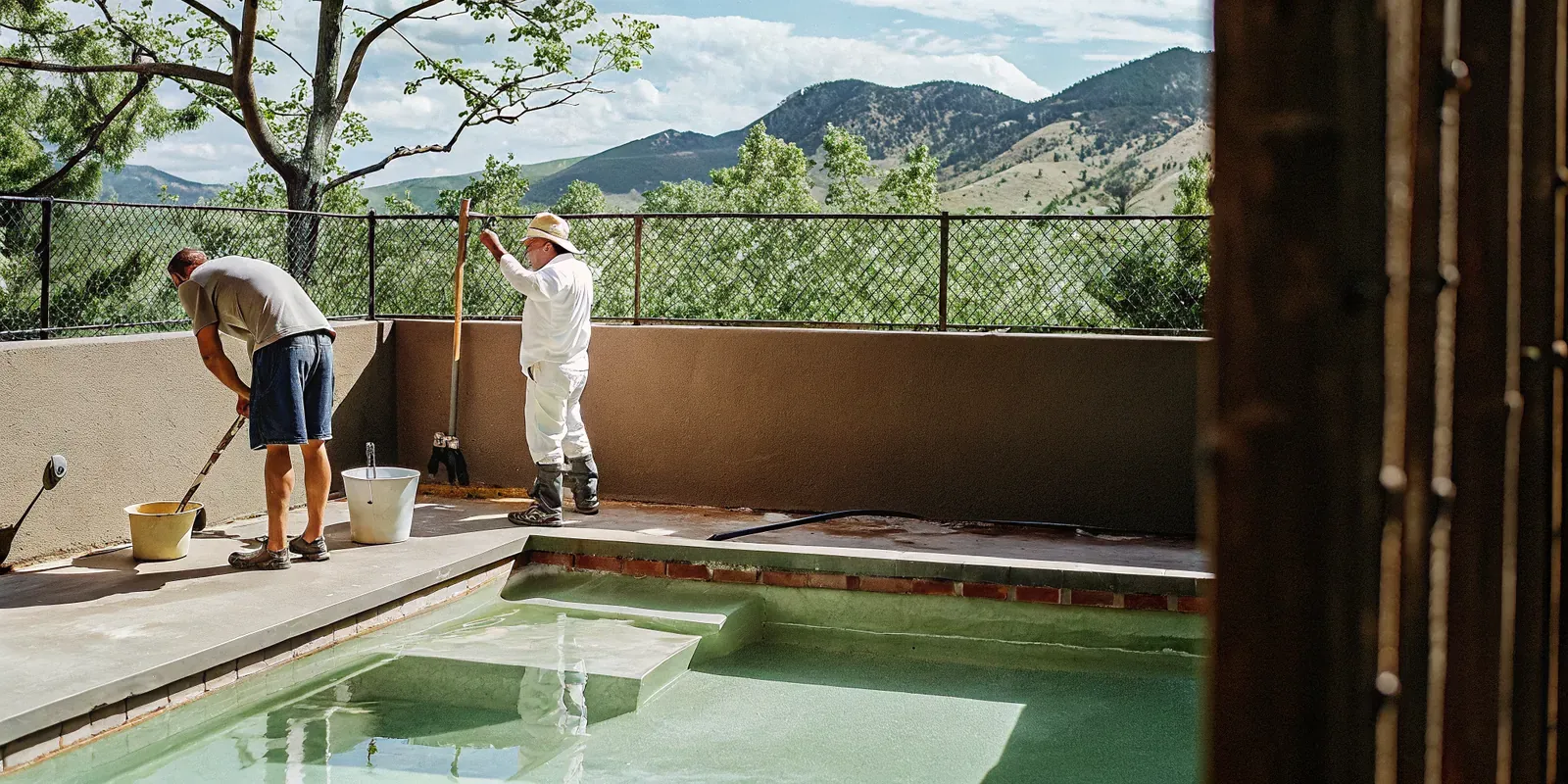 Professional team resurfacing a backyard pool in a sunny Denver neighborhood