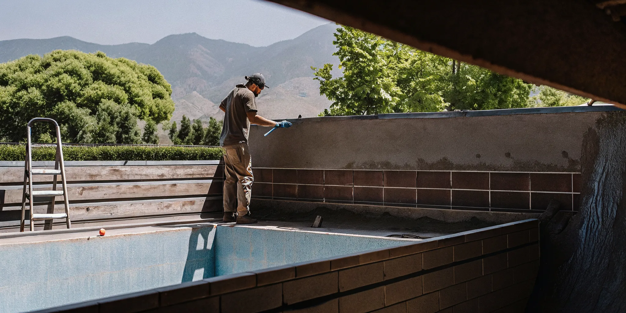 Pool technician resurfacing a backyard pool in Denver