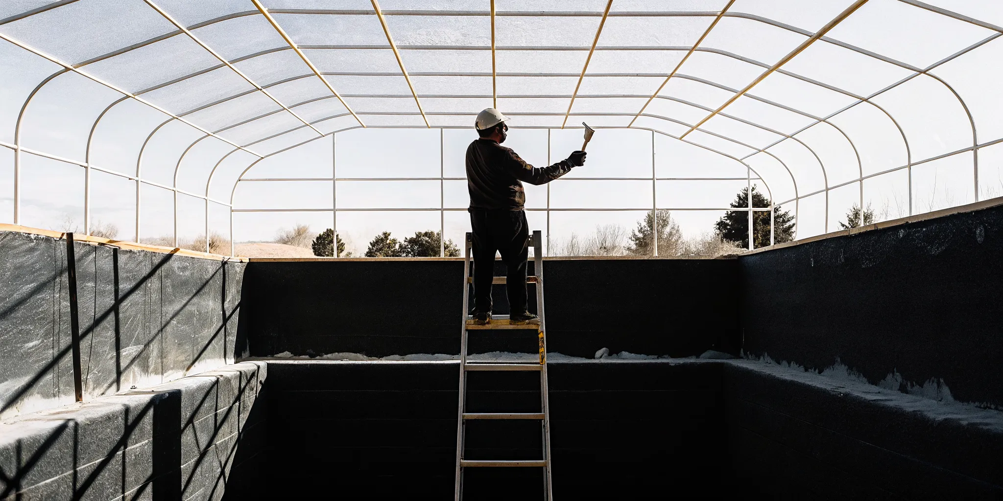 Technician applying fresh plaster while resurfacing a Denver backyard pool