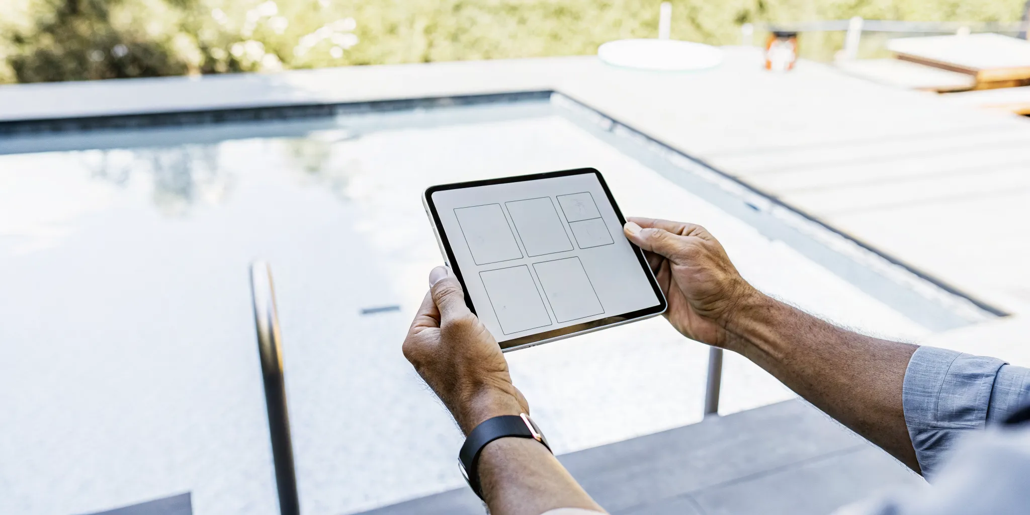 A contractor uses a tablet to prepare a free quote for pool remodeling.