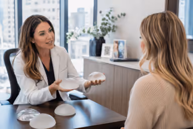 Woman reviewing breast augmentation options with a surgeon in Denver, Colorado for natural-looking results