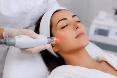 Patient receiving laser resurfacing treatment for sun damage and acne scars in Greenwood, Colorado