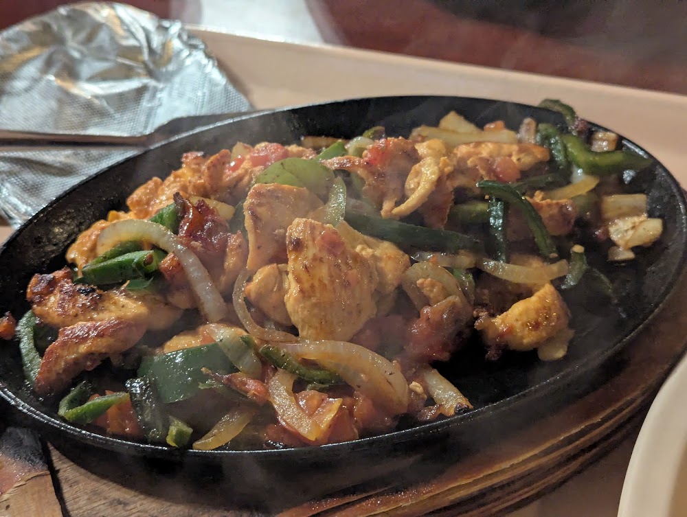 A black skillet with a delicious meal cooking in it.