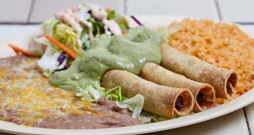 A plate of food with a salad and a wrap.