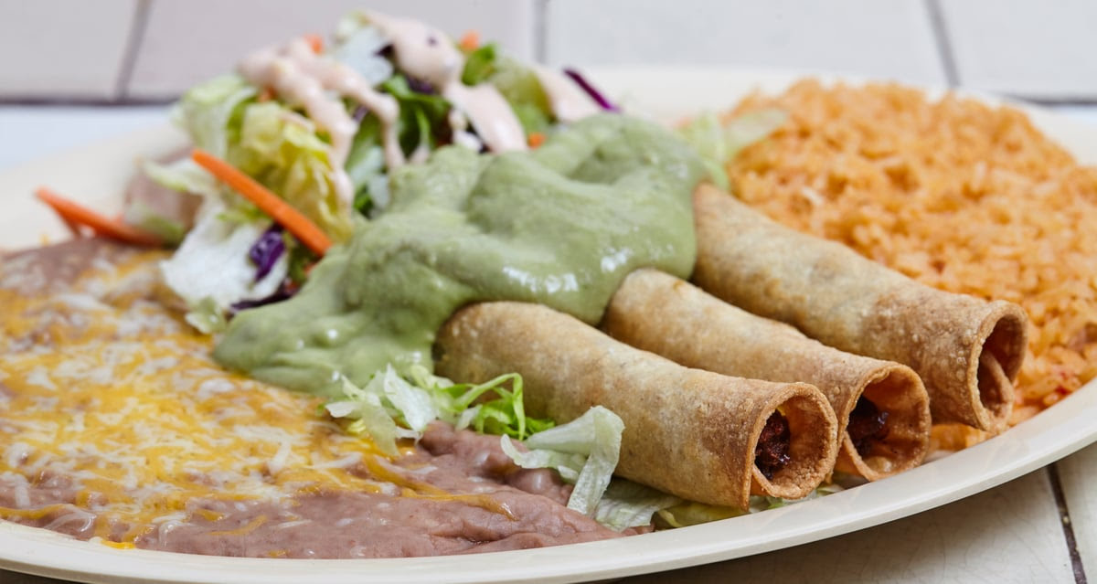 A plate of food with a salad and a wrap.