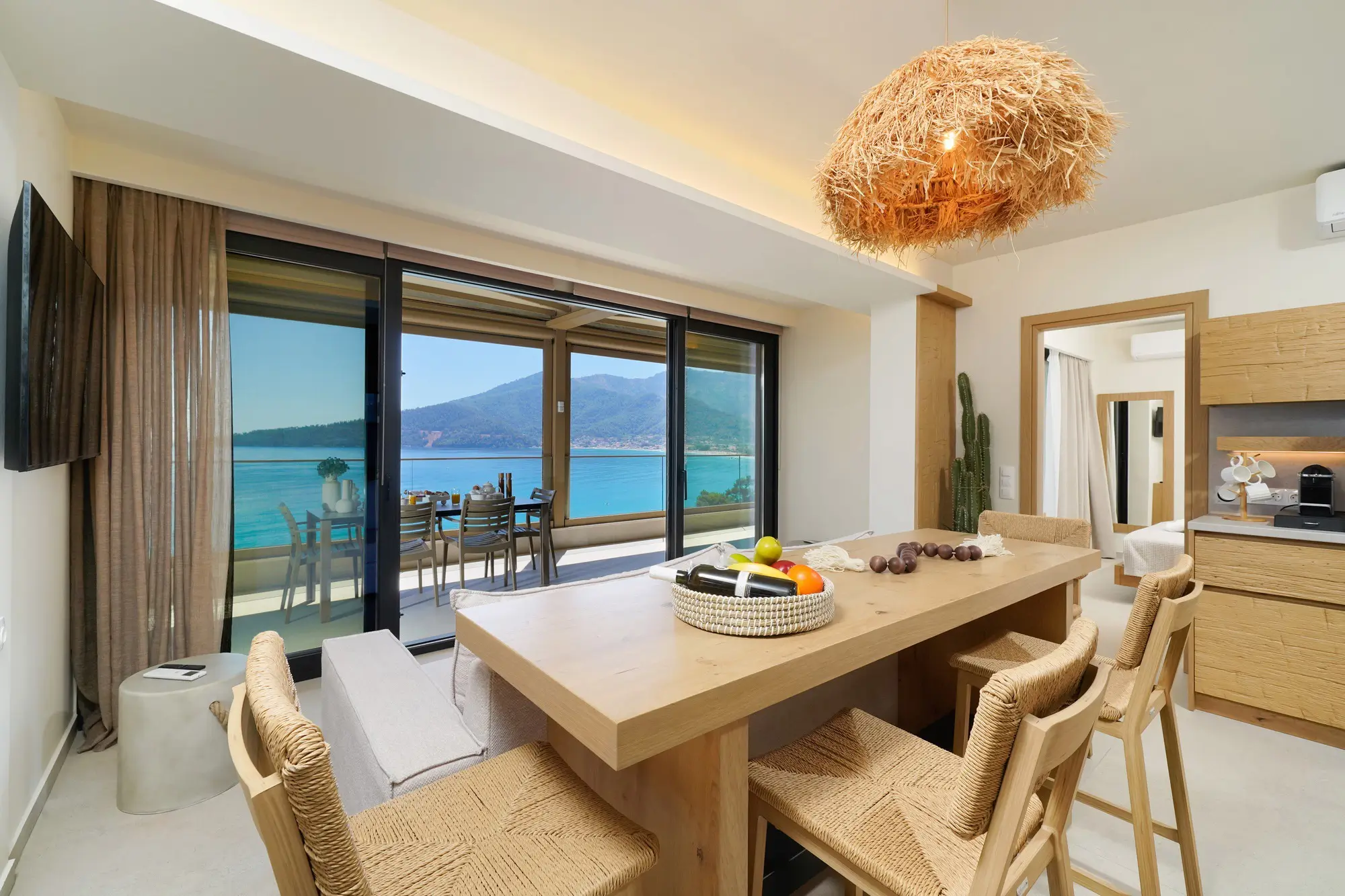 Open-plan kitchen and dining with oak cabinetry and Aegean sea beyond | Kitchen