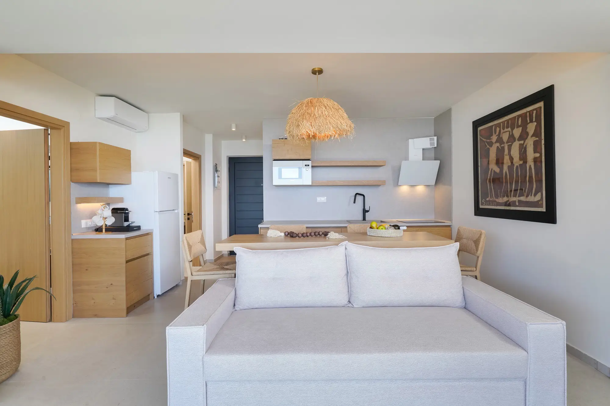 Combined kitchen and dining area with oak cabinetry, stone worktops and sea view | Kitchen