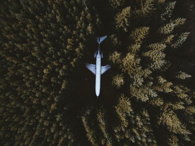 Drone shot capturing an airplane surrounded by a dense forest in Hillsboro, OR.