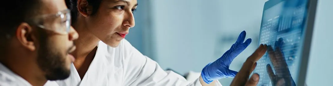 Scientists collaborating on data analysis at a computer in a laboratory
