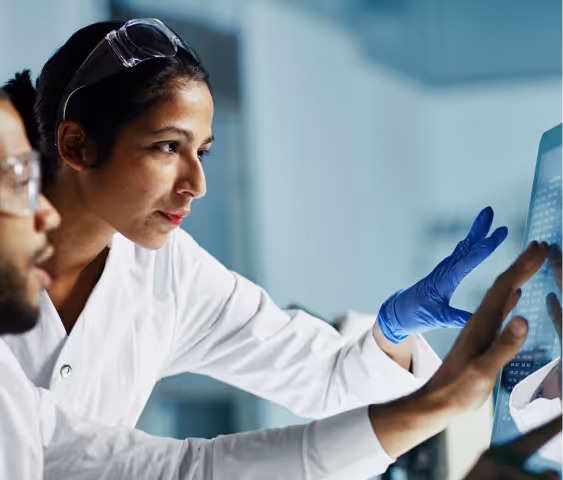 Scientists collaborating on data analysis at a computer in a laboratory.