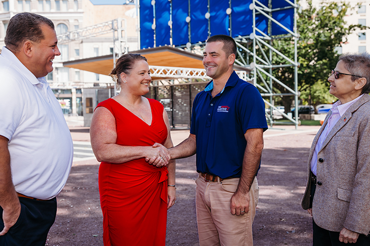 Ann Marie Kochuba-Mantione shaking hands with Mike Harostock on Public Square, with Michael Stadulis and Denise Thomas.