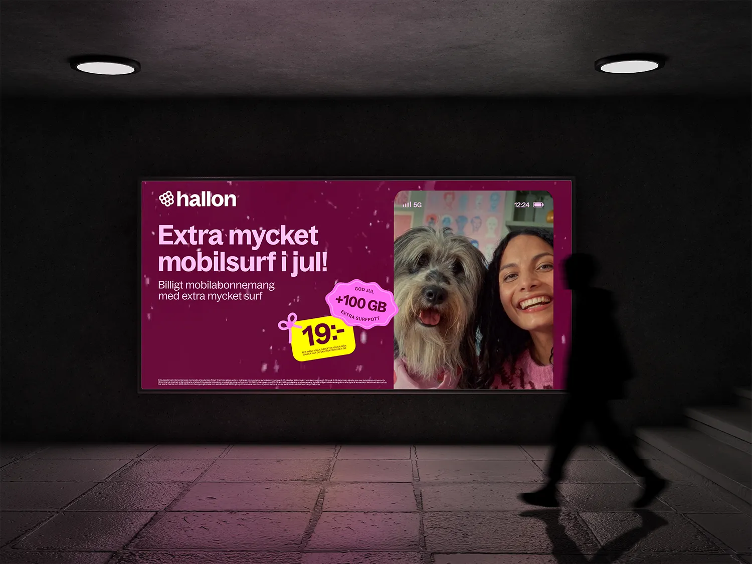 Billboard advertisement for Hallon mobile service offering extra data at 19 SEK with a photo of a smiling woman and dog on a phone screen.