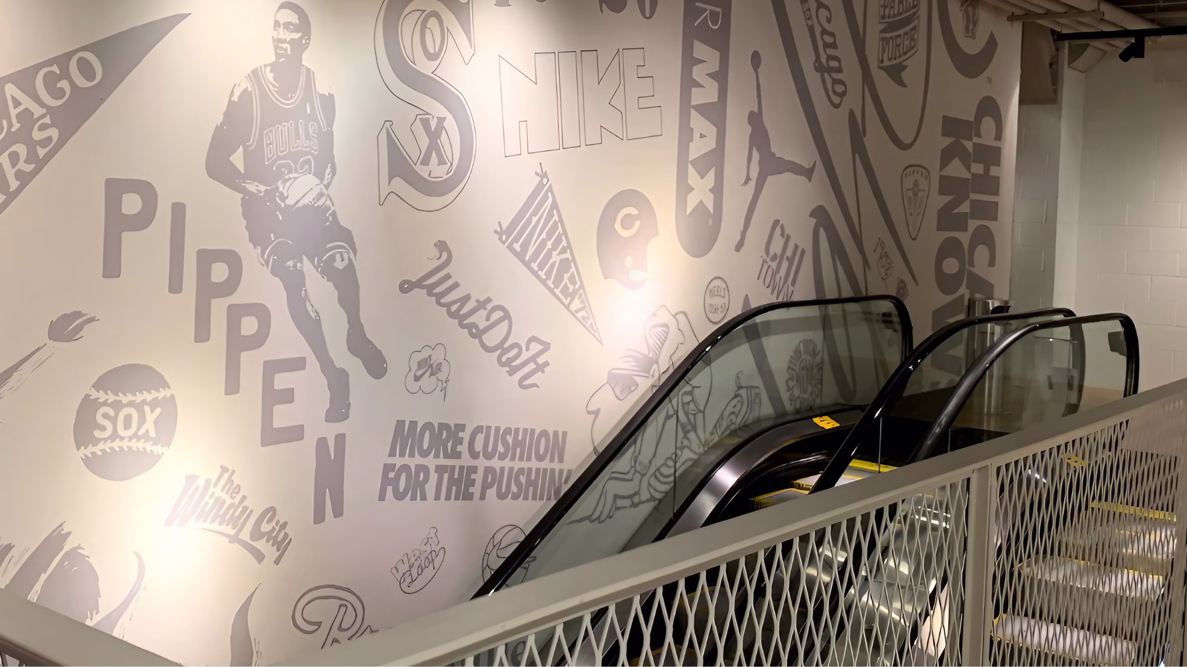 Escalator beside a large monochrome Nike Chicago mural