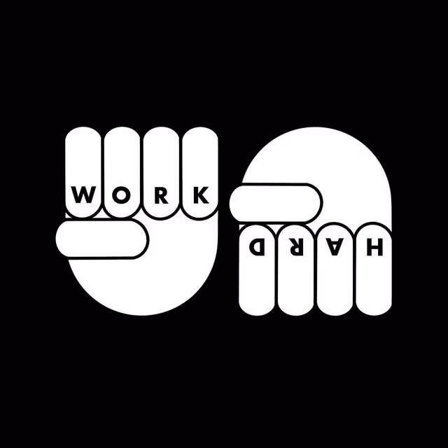 Two white hands spelling “WORK” and “HARD” with their fingers on black