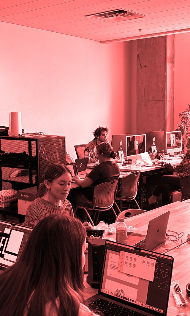 People working at a desk on computers