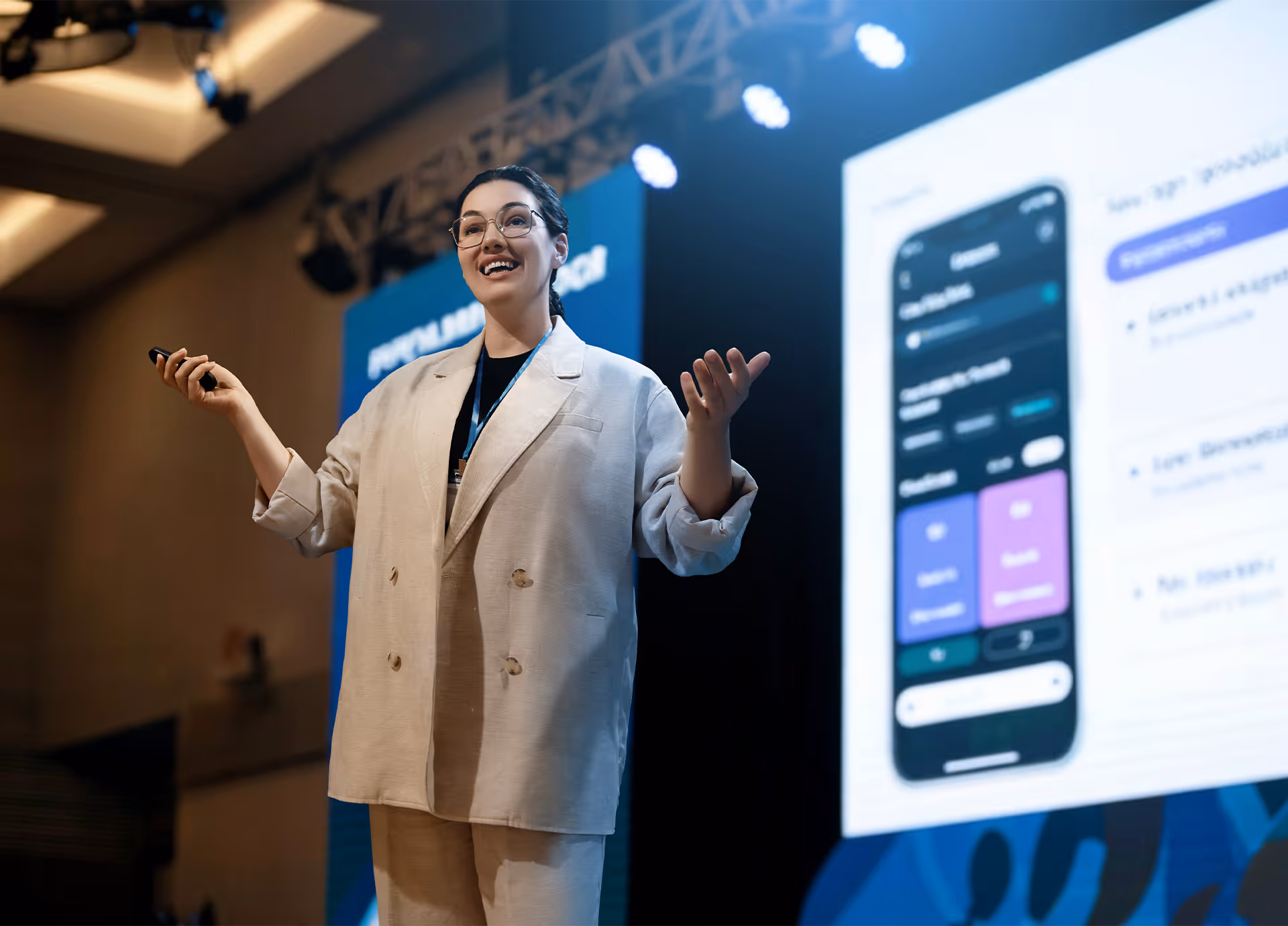 Eine Expertin präsentiert ein digitales Produkt auf einer Bühne. Erfolgreicher Website-Launch, Qualitätssicherung und Performance-Optimierung.