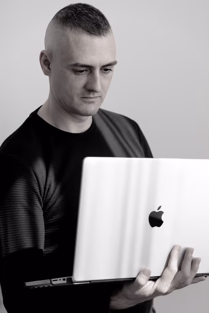 Tomi Novelli, Gründer der KROND Agentur, arbeitet konzentriert an einem Webflow-Projekt an seinem Laptop. Einblick in den Arbeitsalltag eines Digital Architects in Wien.