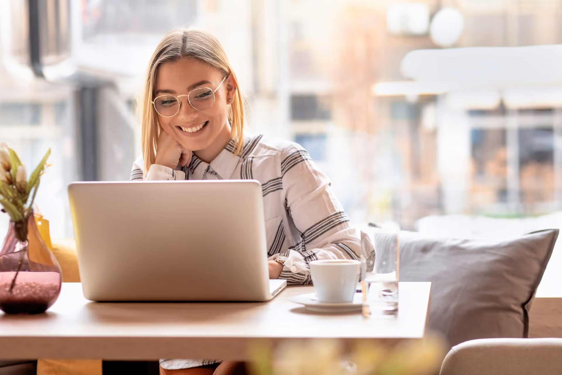 Unternehmerin bearbeitet Website-Inhalte selbstständig am Tablet im Café — visuelles Webflow CMS ohne Entwickler