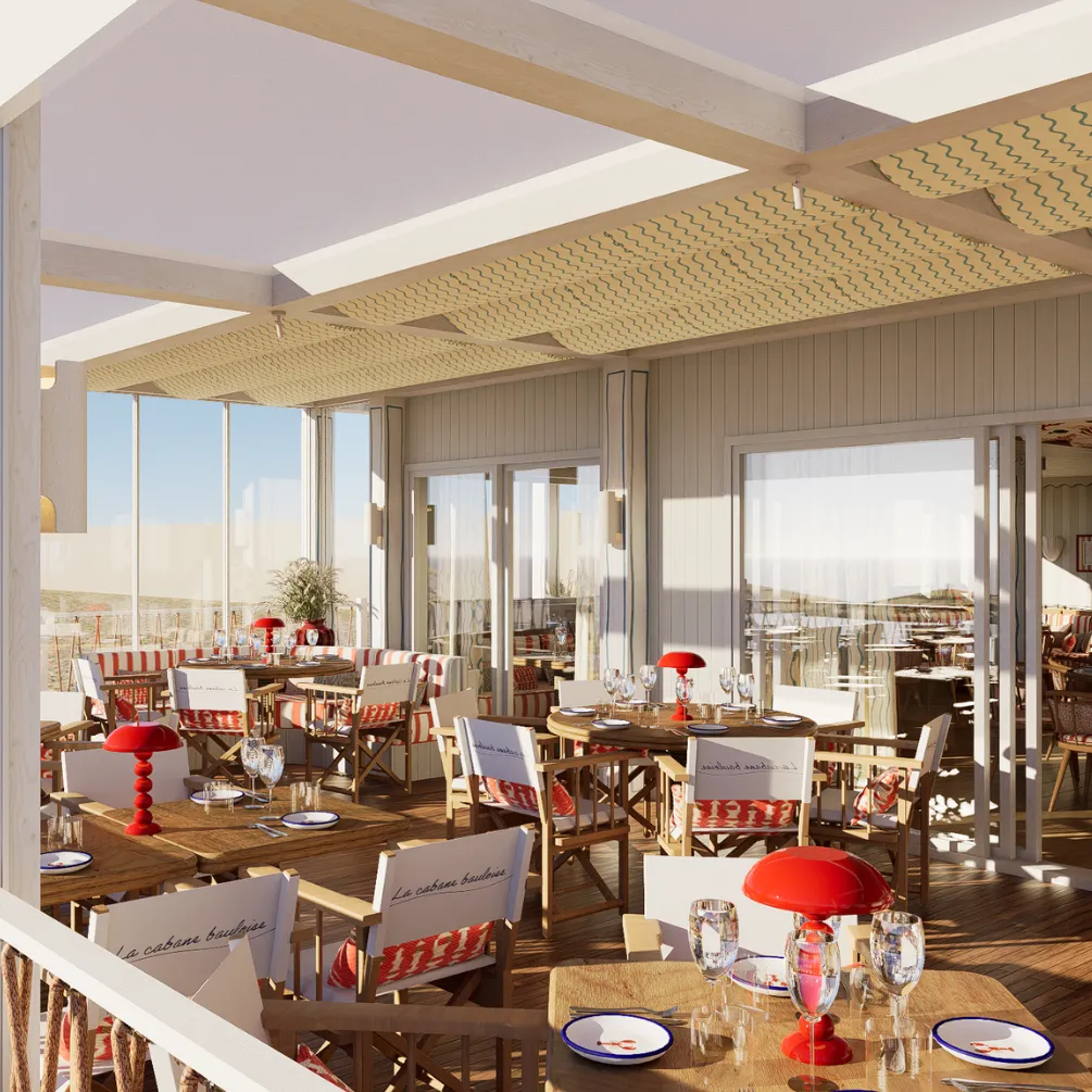 Terrasse de restaurant lumineuse avec tables en bois, chaises en toile marquées 'La cabane bauleise', nappes rouges et blanches, et lampes rouges.