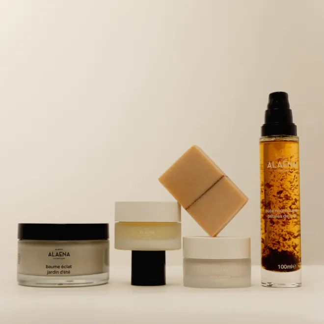 Quatre produits de soin visage ALAENA, incluant baume, huile nourrissante et savon, disposés sur fond beige.