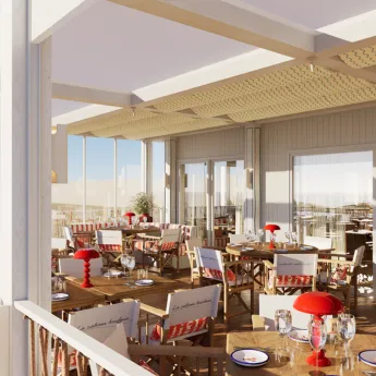 Terrasse de restaurant avec tables en bois, chaises avec coussins, et lampes rouges pour une ambiance chaleureuse.