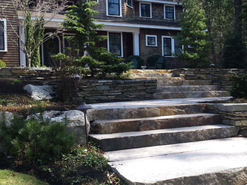 Person using a surface cleaner to pressure wash wet terracotta floor tiles near a pool.