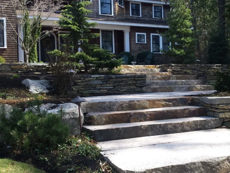 Person using a surface cleaner to pressure wash wet terracotta floor tiles near a pool.