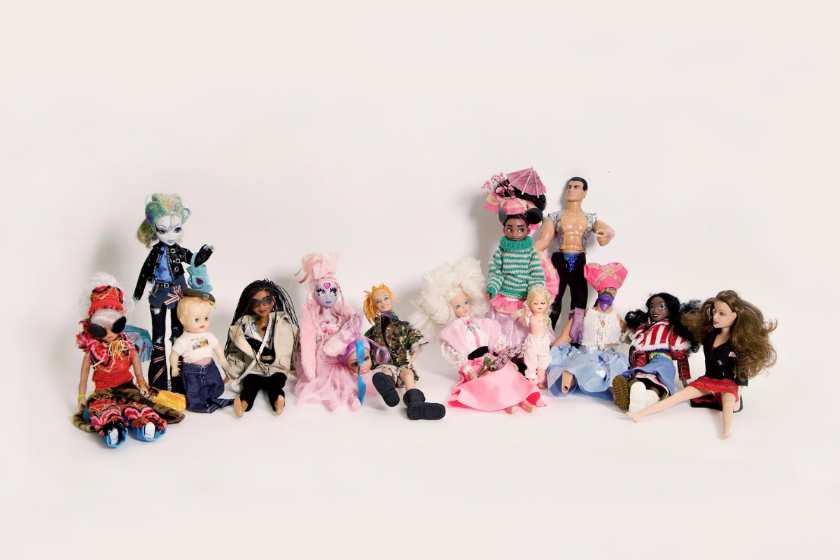 an assortment of dolls wearing handmade custom outfits and costumes