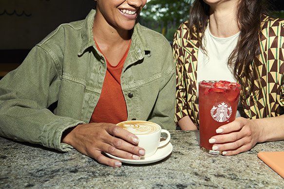 Two customers enjoying Starbucks latte and iced drink