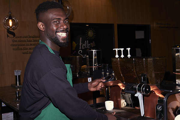 Starbucks barista smiling at espresso machine
