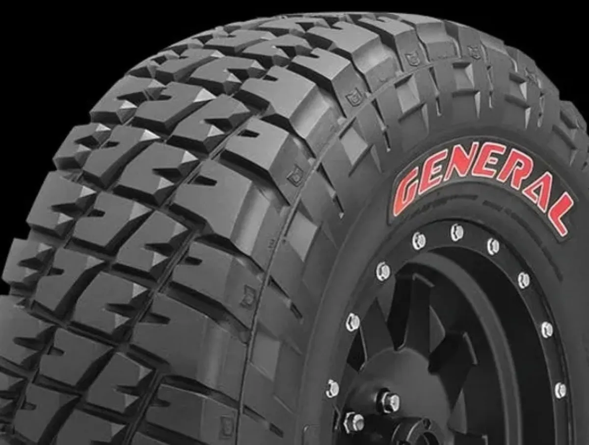Close-up of a rugged off-road tire with deep treads and the brand name General in red on the sidewall.