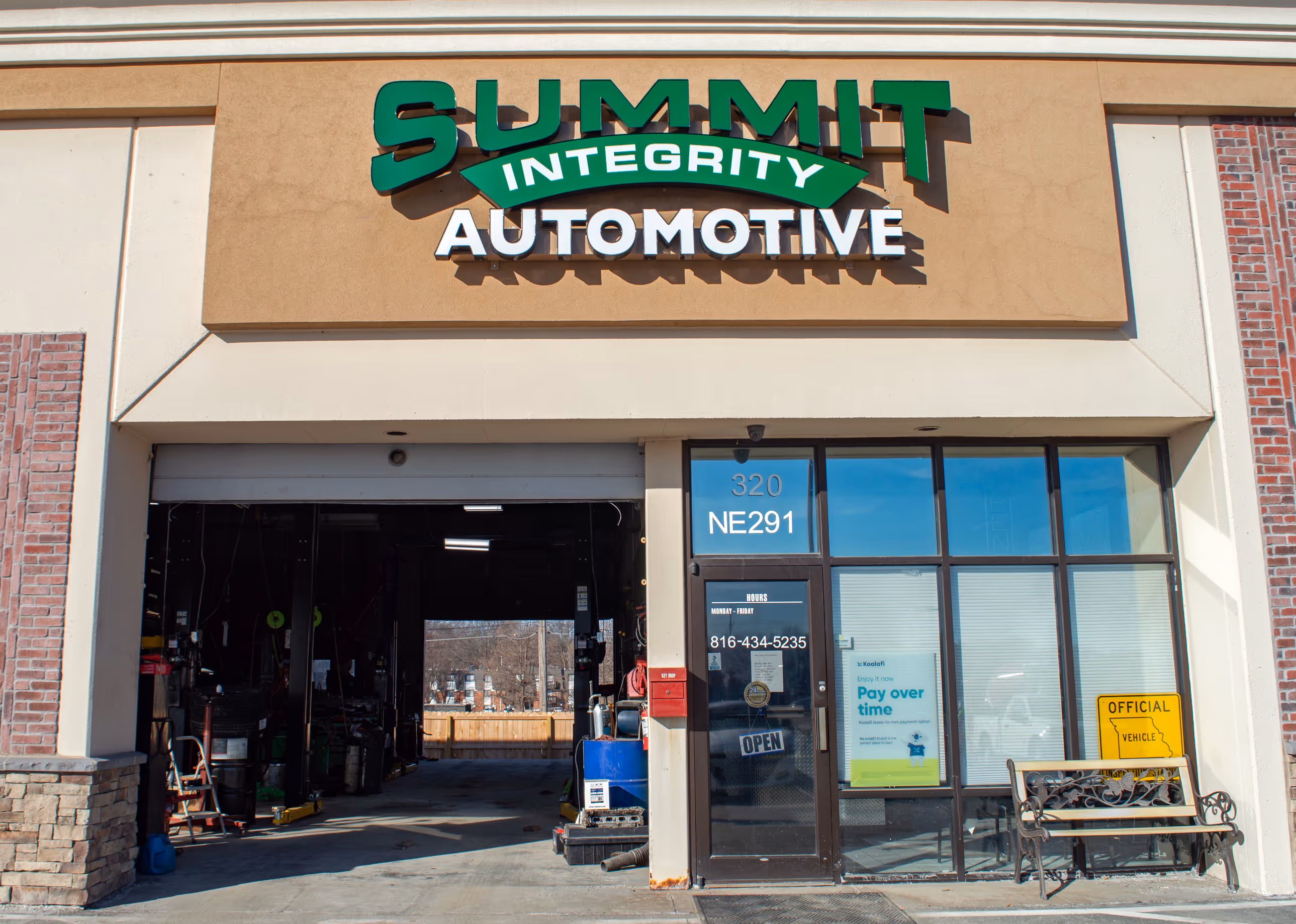 Exterior sign for Summit Integrity Automotive on a building under a blue sky.