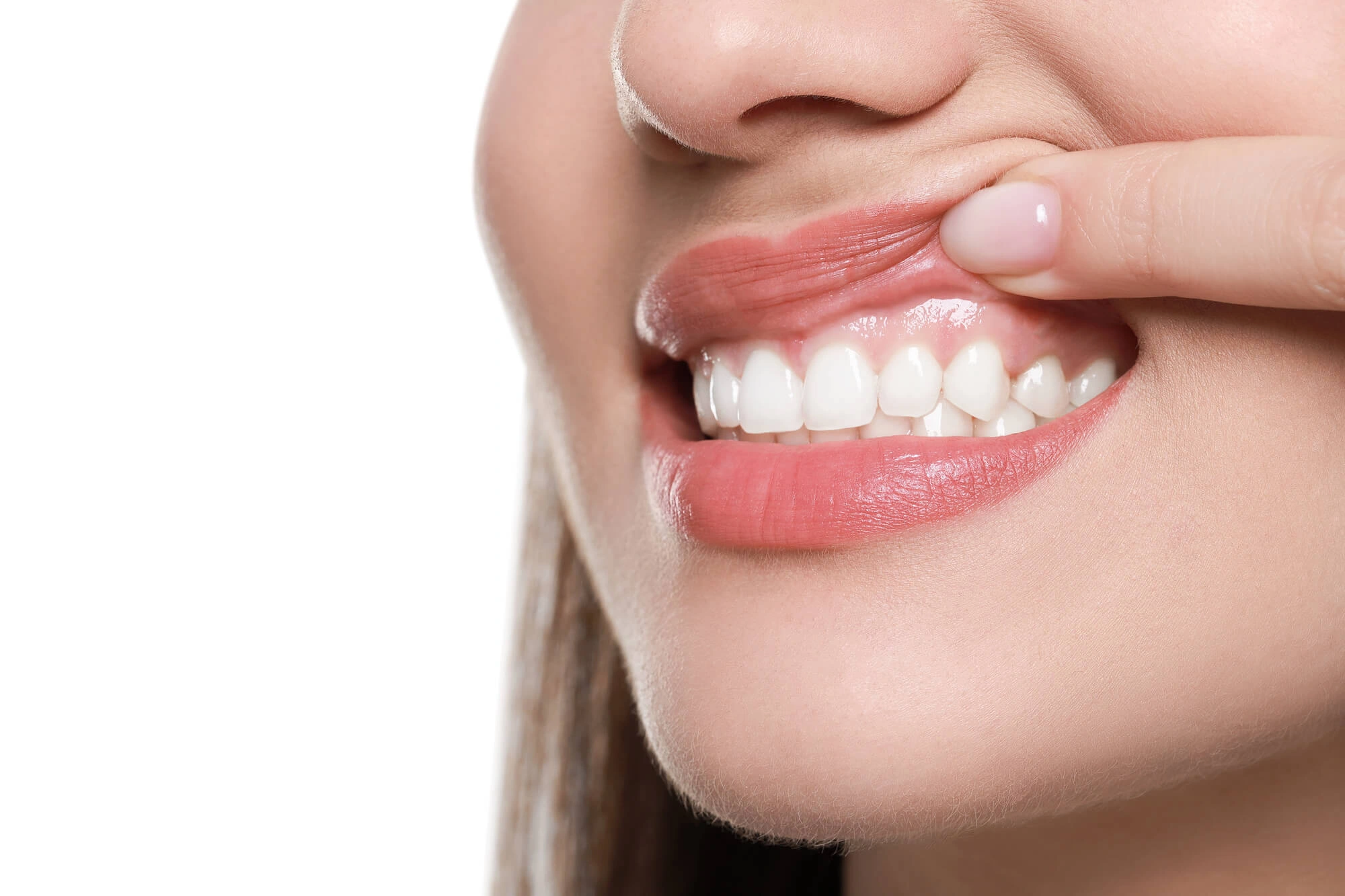Close-up of a person lifting upper lip to show clean, healthy teeth and gums.