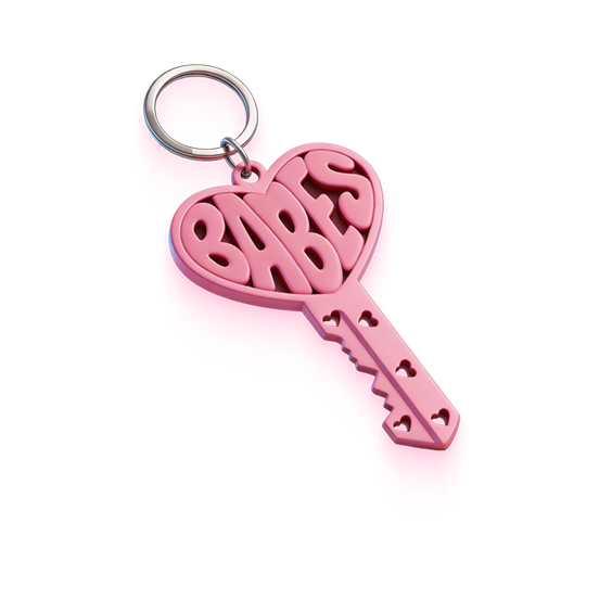 Pink heart-shaped keychain with the word 'BABES' and small heart cutouts on the key shaft.