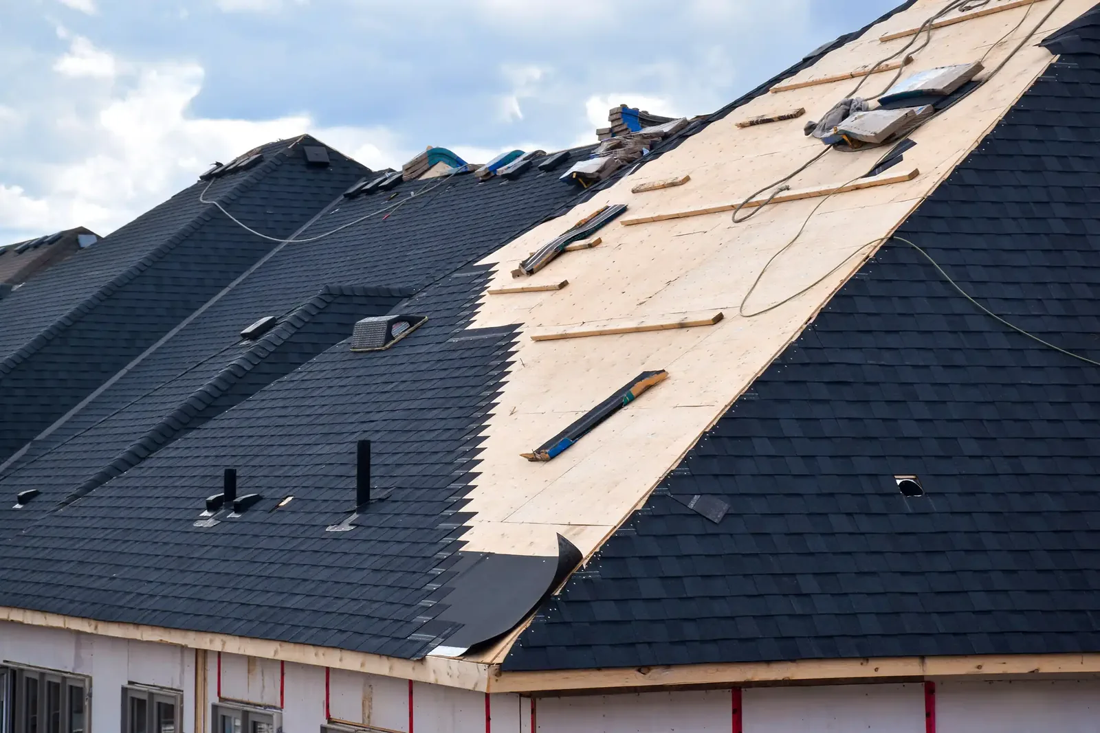 Vue aérienne d'une toiture en bardeaux d'asphalte en réfection à Granby, ancien revêtement en partie retiré.