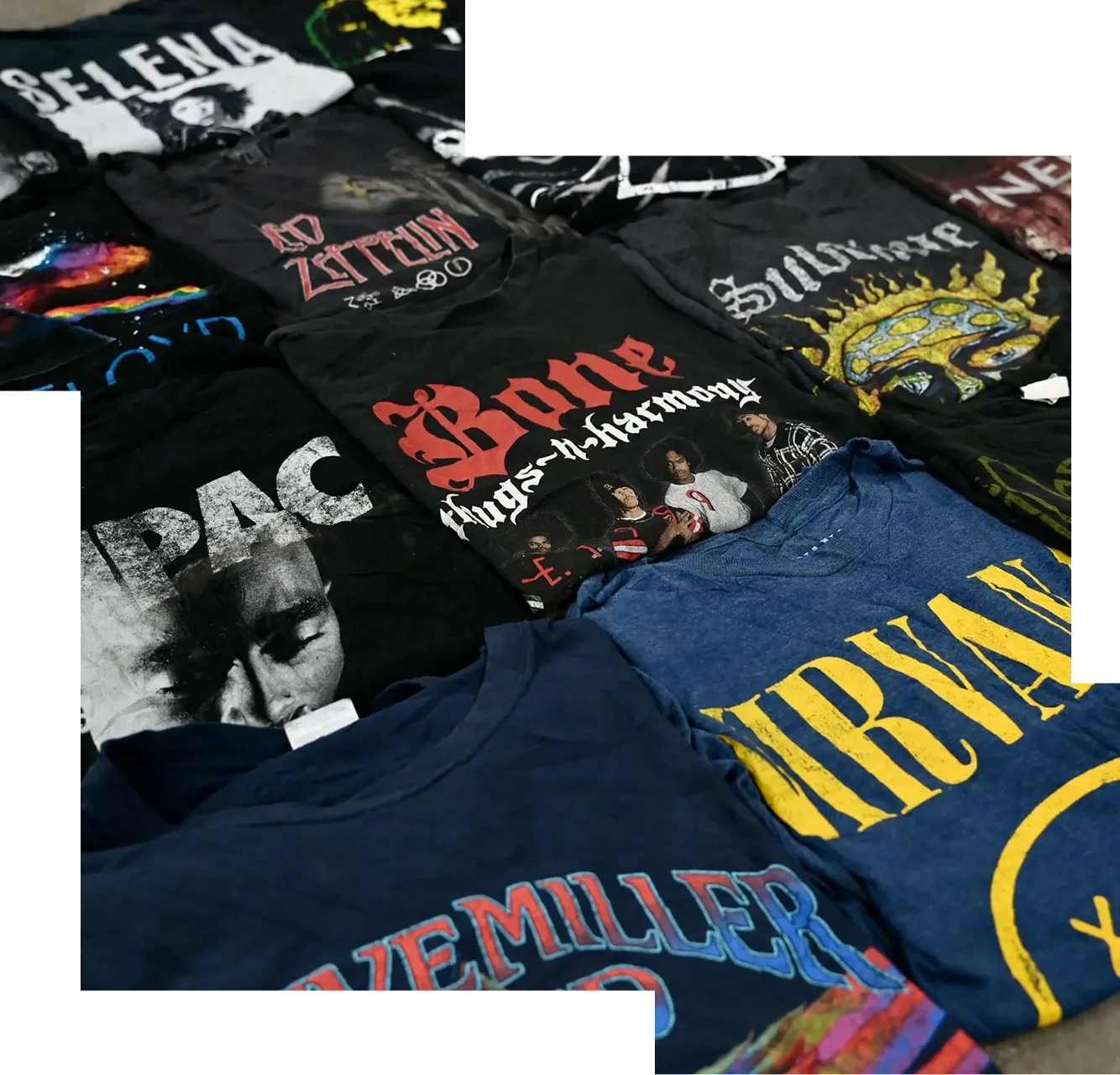 Collection of folded vintage band T-shirts including Nirvana, Tupac, Led Zeppelin, Bone Thugs-n-Harmony, and Selena.
