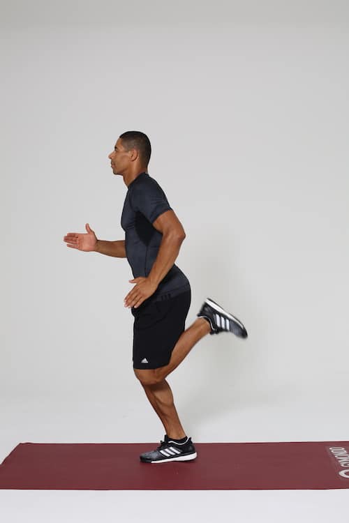 Mann joggt auf dunkelroter trainingsmatte