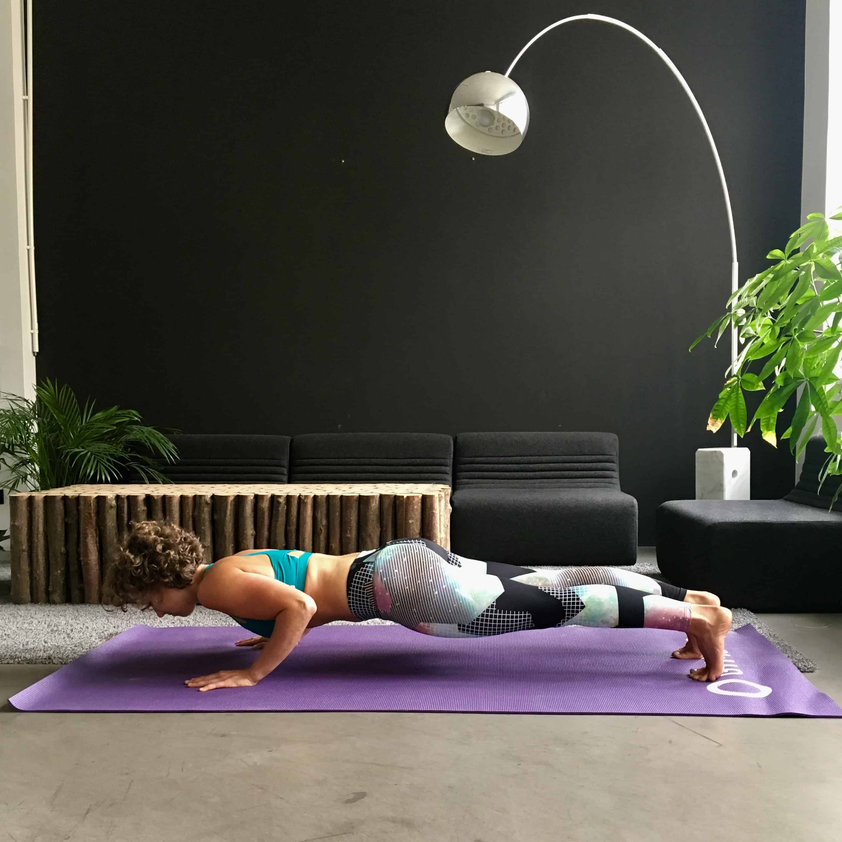 Frau macht Push Ups auf lila trainingsmatte