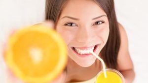 Frau mit Orange und Orangensaft