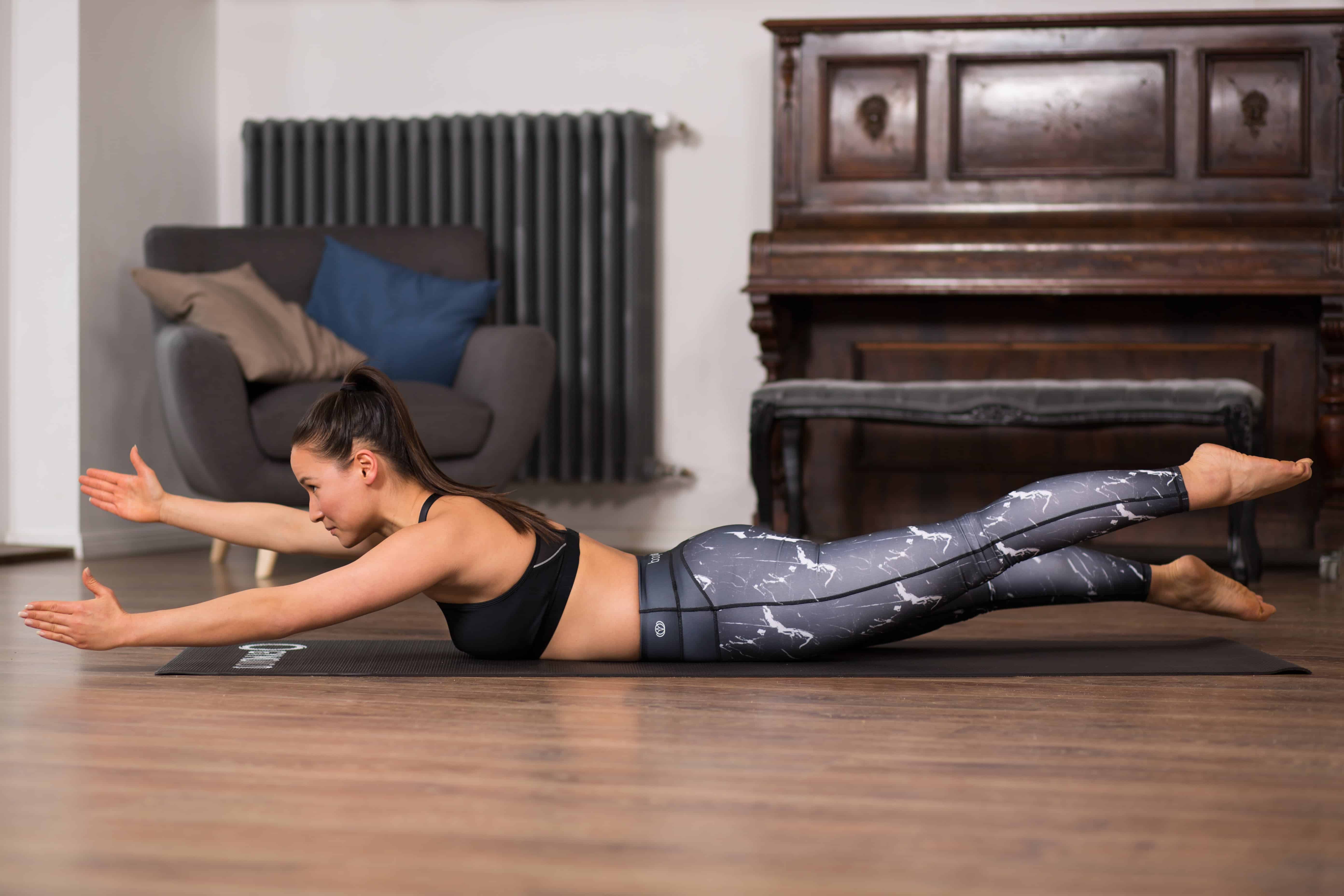 Frau macht Übung Swimming aus dem Pilates