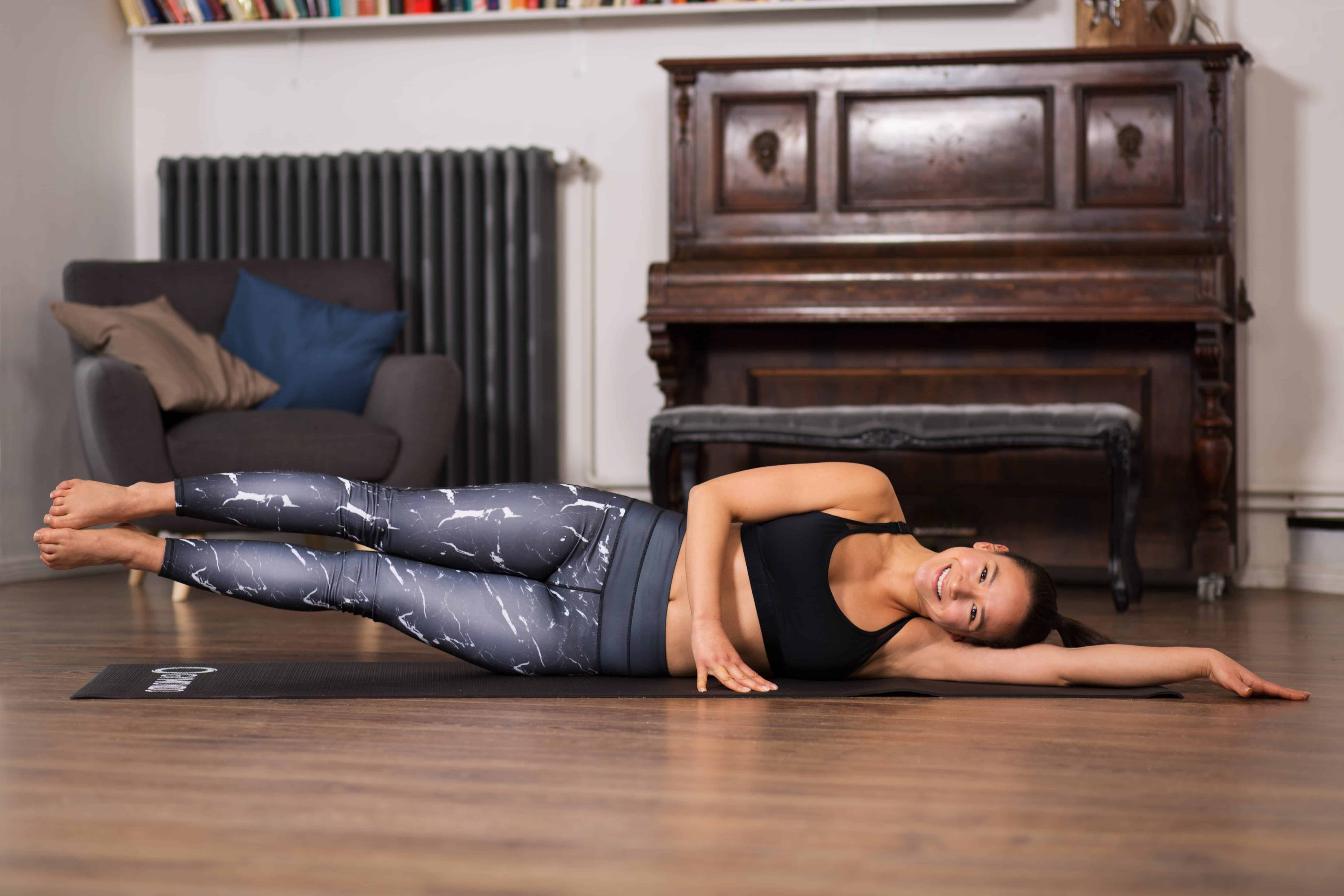 Frau macht Pilates Übung Side Kick