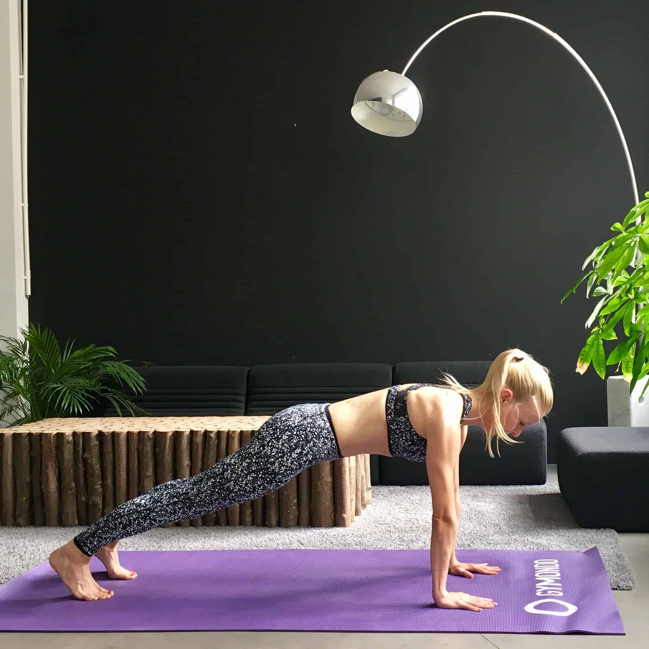 Frau macht Yoga Sonnengruß Brett auf lila Trainingsmatte