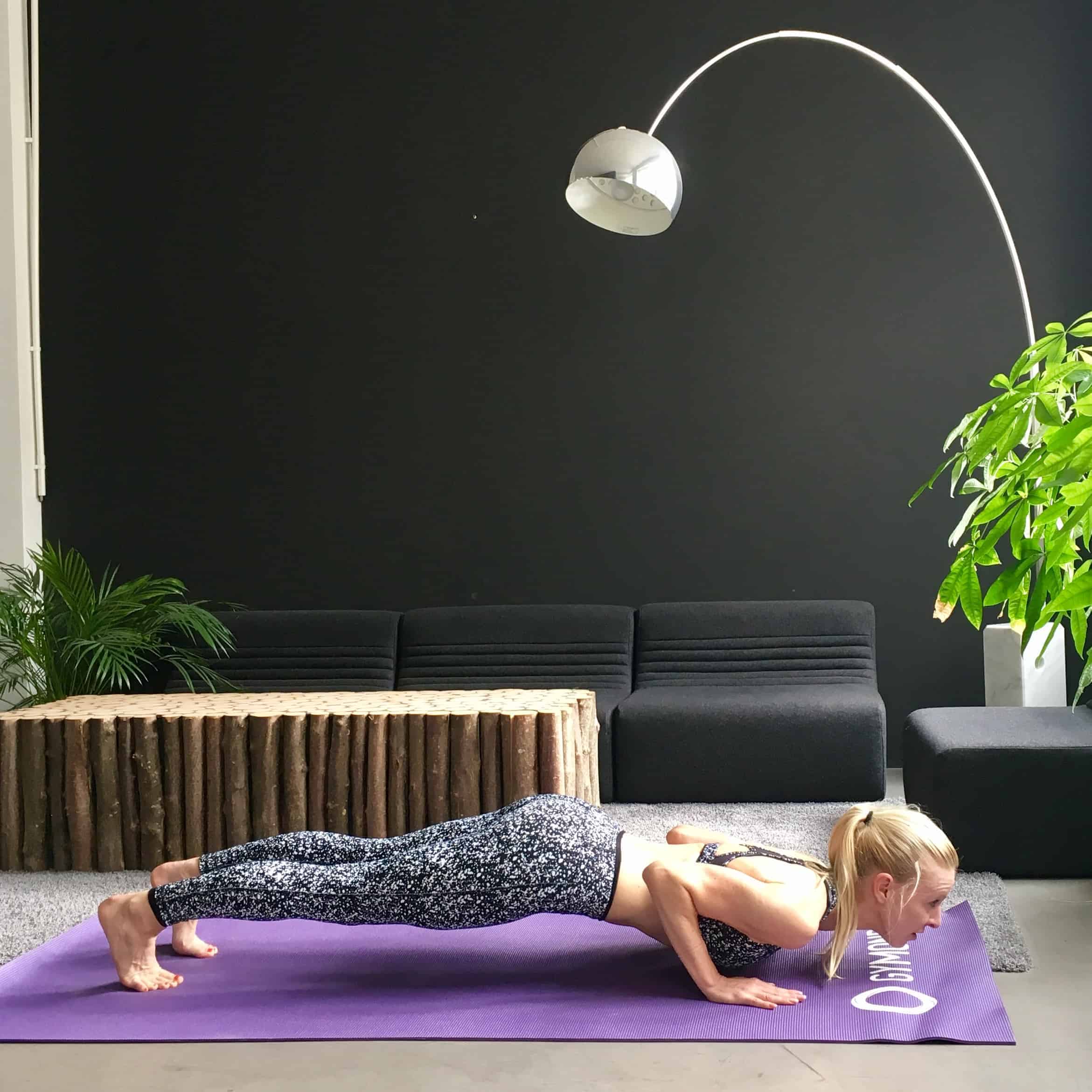 Frau macht Yoga Sonnengruß tiefes Brett auf lila trainingsmatte