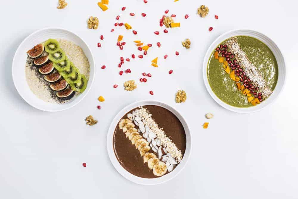 3 Schüsseln mit Frühstücksbrei mit Quinoa, Kakao und Spinat