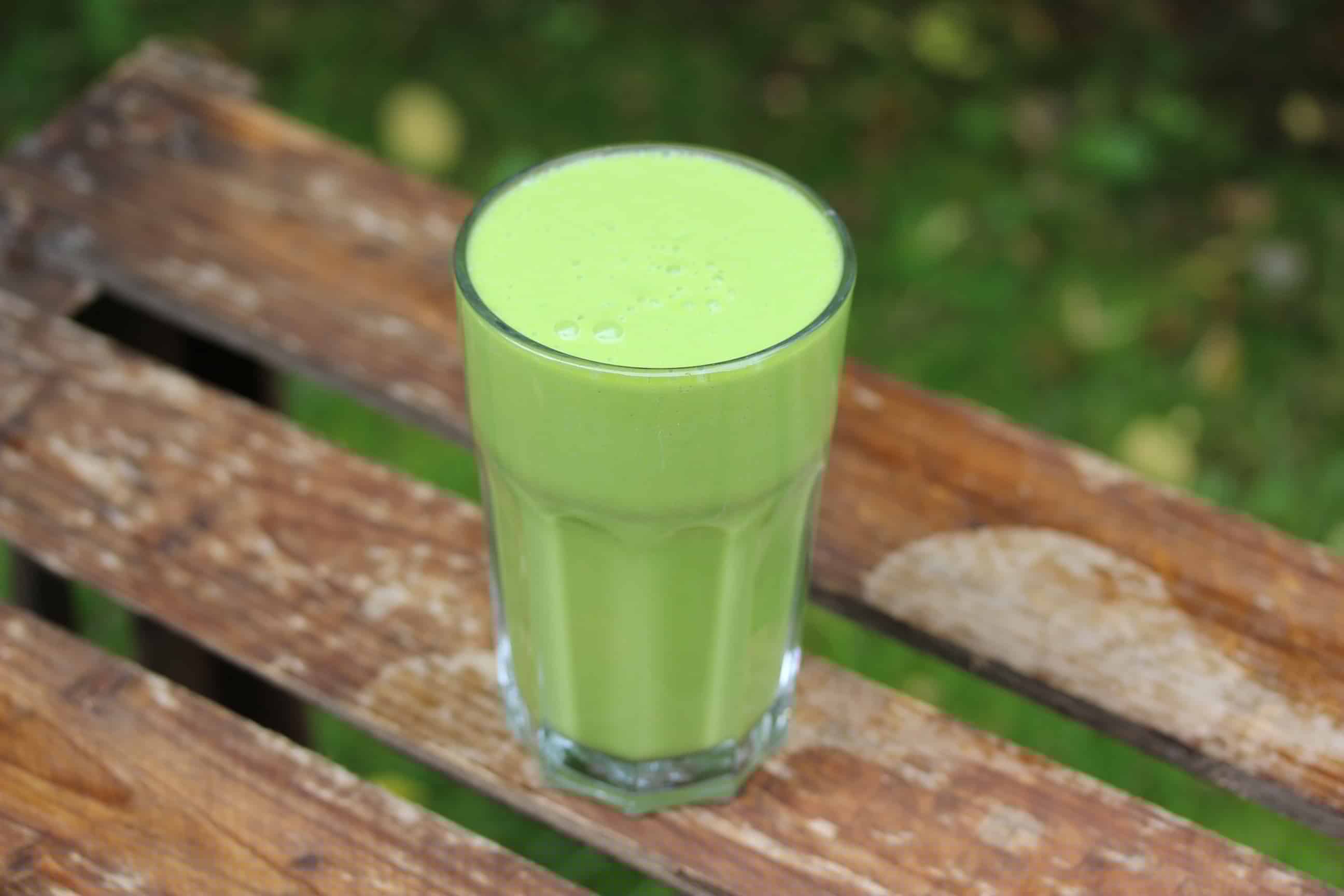 SuperGoodFood Green Avocado-Coconut Smoothie in Glas auf Holztisch
