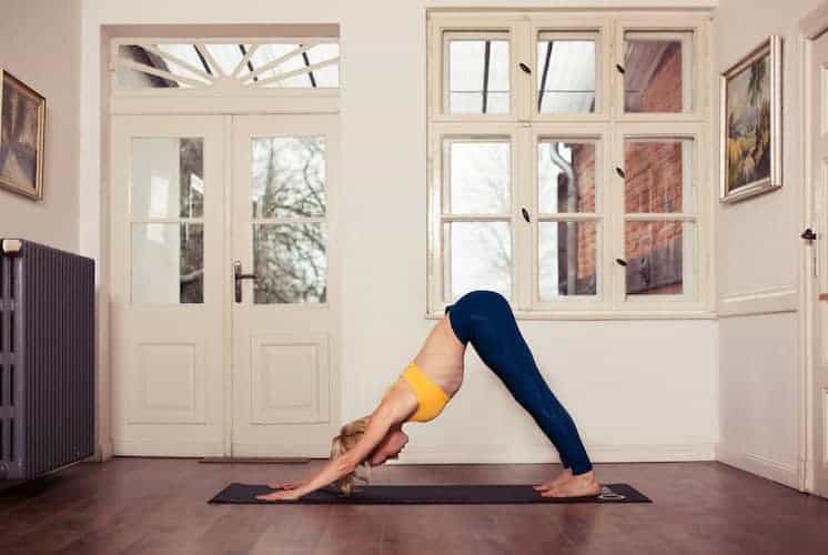 frau macht yoga herabschauender Hund seitlich