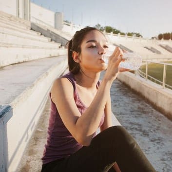Sportlerin trinkt Wasser nach dem Workout.