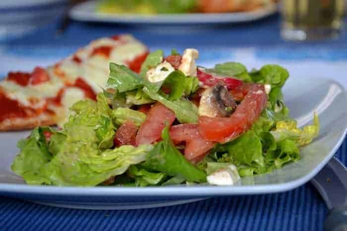 Grüner Sommersalat mit Tomaten, Feta und Pilzen an einem Mango-Pfirsich-Dressing