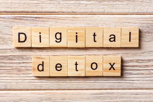 Holzhintergrund darauf Würfel mit Buchstaben die die Worte digital Detox ergeben